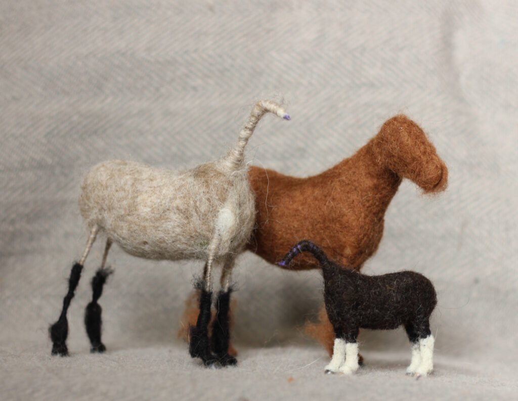 Needle-felted model horses in progress.